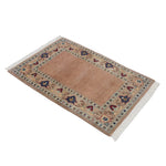 玄関マットとしても使いやすいサイズ感のアフガニスタン絨毯を斜め上から撮影。温かみのあるベージュ地と淡い縁取りがやさしい印象。