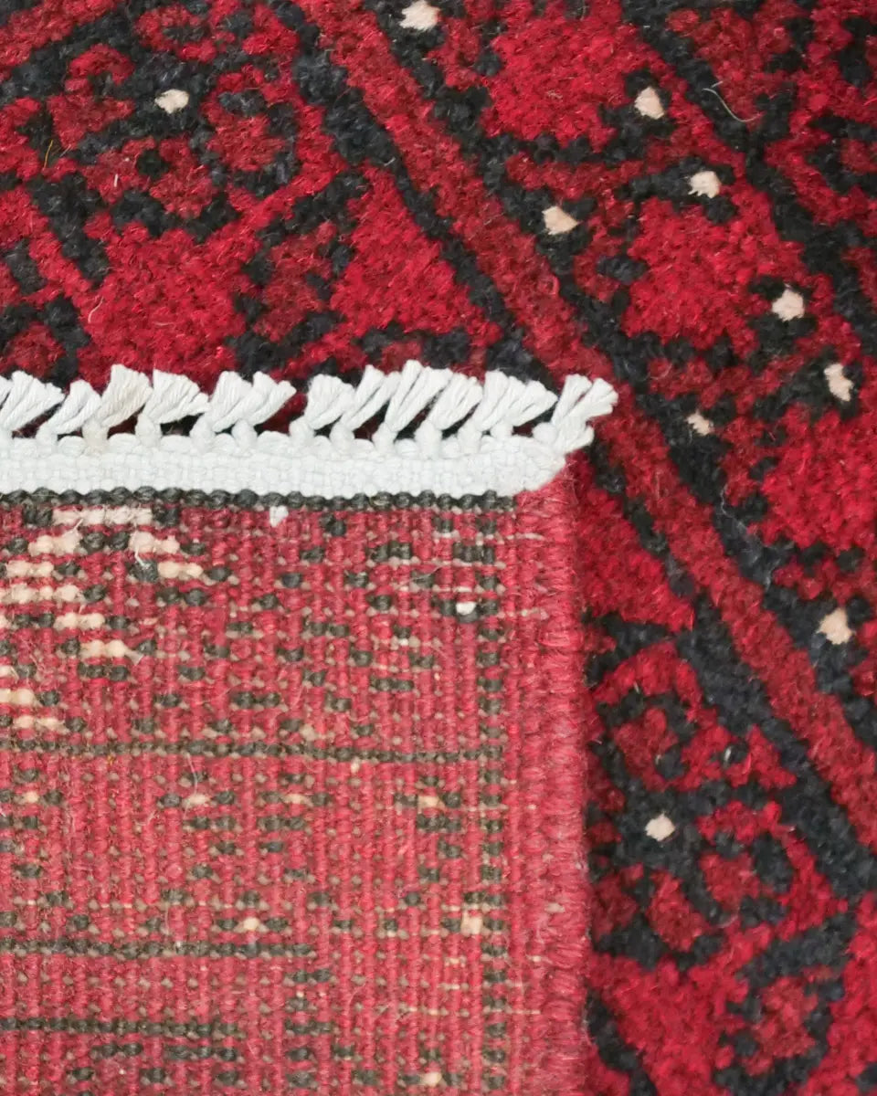 深い赤色を基調にした力強い幾何学模様が施されたアフガニスタン絨毯(51×68cm、ウール製)