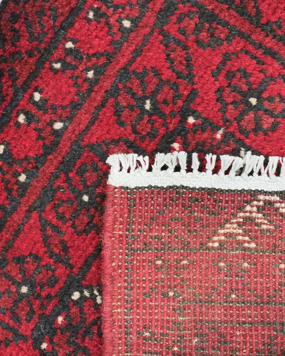 深い赤色を基調にした力強い幾何学模様が施されたアフガニスタン絨毯(51×68cm、ウール製)