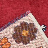 赤い背景に立つライオンを中央に描いたシーラーズ産の手織りギャッベ。周囲にはカラフルな花柄モチーフが並び、ウール素材で丁寧に織られた一点もののアートラグ。