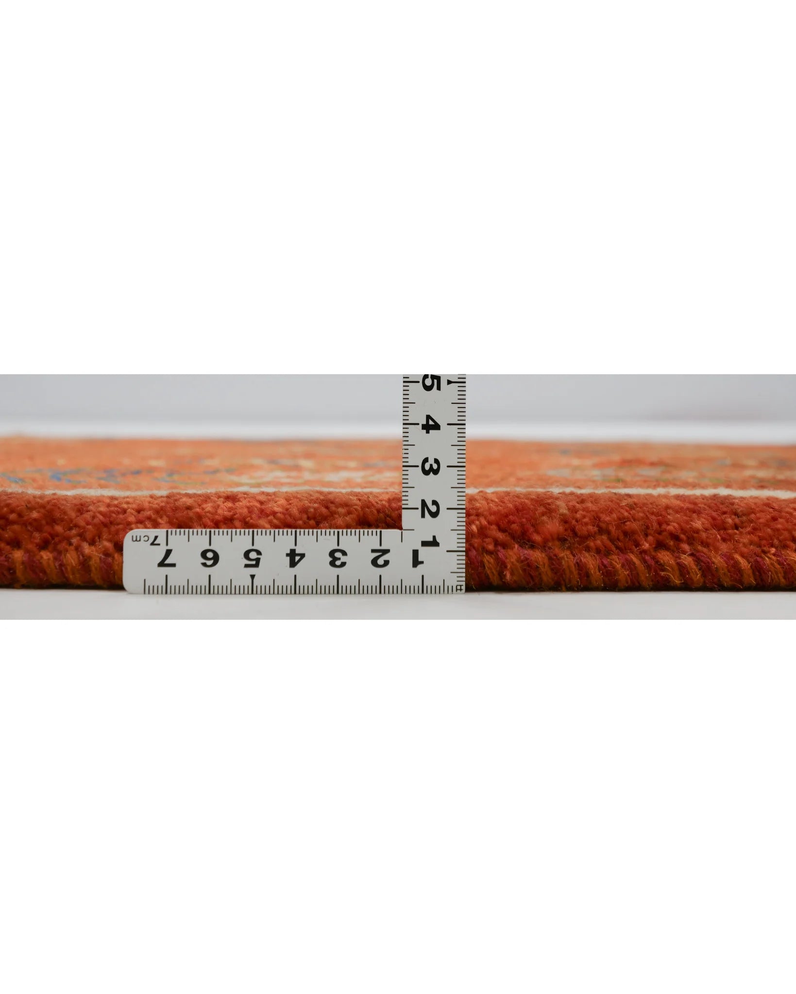 ペルシャギャッベの側面と厚みを測る画像。定規で約2.5cmの厚みを示し、しっかりとしたウールのボリューム感を表現。
