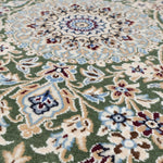 中央メダリオン部分を接写したナイン産のペルシャ絨毯。繊細な花模様とブルー系の装飾が印象的。