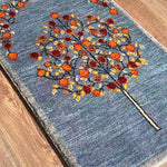 ペルシャギャッベの玄関マット、ライトブルーとグレーのカラーミックス、ザクロの木の緻密な織り込み、イラン・シーラーズ産、ファインクオリティウール素材。