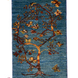 青い背景に生命力あふれる一本の木が描かれたギャッベ