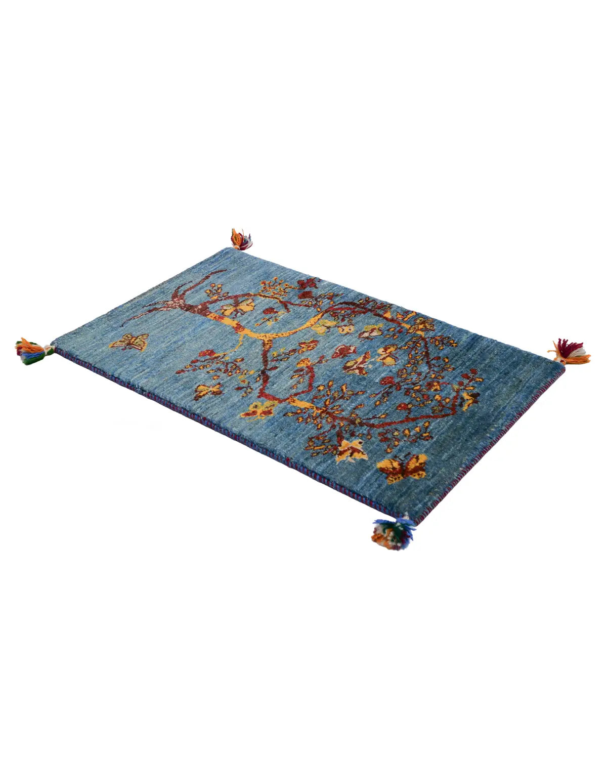 深いブルーの地に枝を広げる木を織り込んだ手織りギャッベ