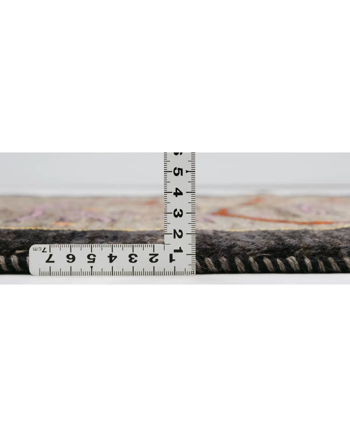 SATHI RUGS ペルシャ絨毯 シーラーズ産 ウール手織りギャッベの定規で厚みを計っている写真