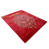 赤いフィールドに、青い幹と小花が広がる生命の樹文様のギャッベ