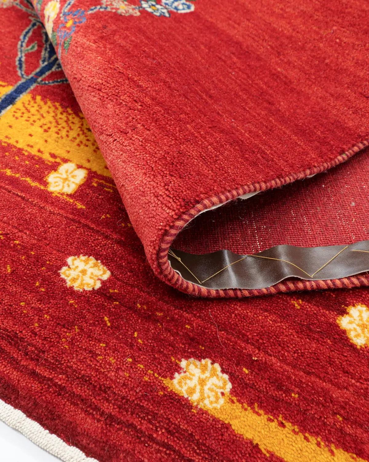 花々が全体に広がる赤色ベースの手織りラグ