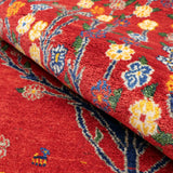 赤地に生命の樹と小花が織り込まれた、温もりある手織り絨毯