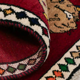 シーラーズ産の手織りライオンギャッベ。深紅の背景にユニークな表情のひょうが描かれたウール製ラグ。サイズ65×100cmの一点もの。玄関マットや壁掛けにも適したアート性の高いペルシャ絨毯。
