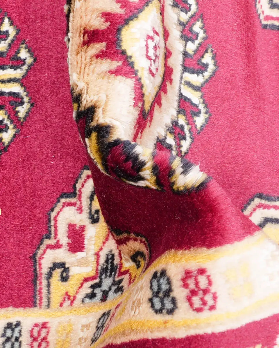 赤を基調としたパキスタン絨毯。中央にはひし形のジャルダン柄と楕円形のボハラ柄が交互に並び、周囲は繊細な模様で縁取られている。