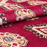 赤を基調としたパキスタン絨毯。中央にはひし形のジャルダン柄と楕円形のボハラ柄が交互に並び、周囲は繊細な模様で縁取られている。