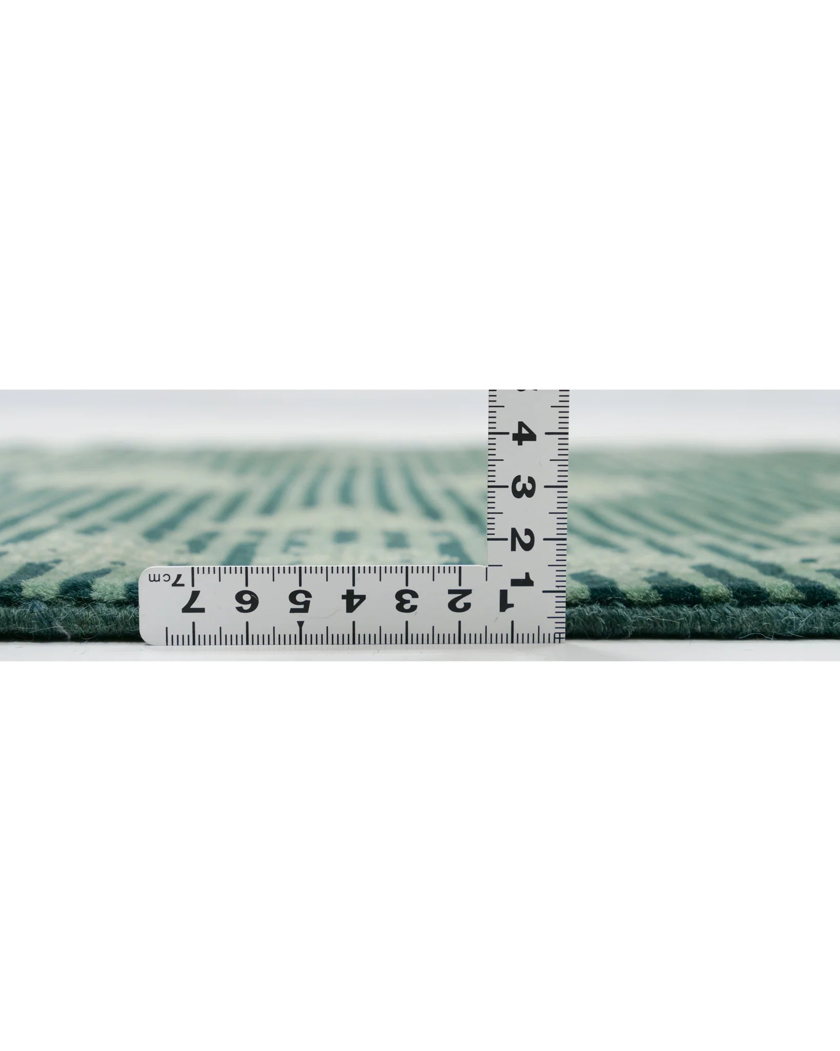 パキスタン絨毯の断面を撮影。厚みは約1cmで、密に織られたウールの質感が確認できる。