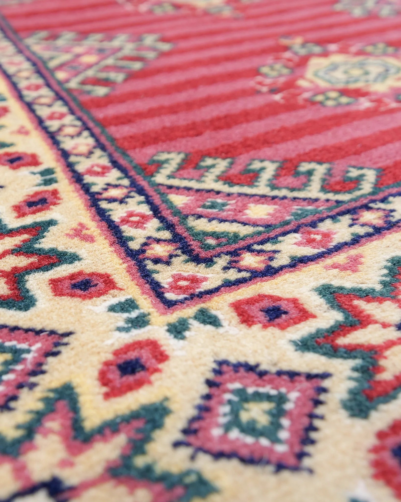 パキスタン・ラホール産の手織り絨毯。赤を基調にしたジャルダール柄とストライプ模様の伝統デザイン。