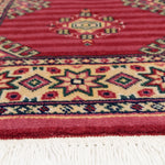 ウール100％で織られたパキスタン絨毯。赤色ベースに幾何学模様とボーダーが施された伝統工芸品。