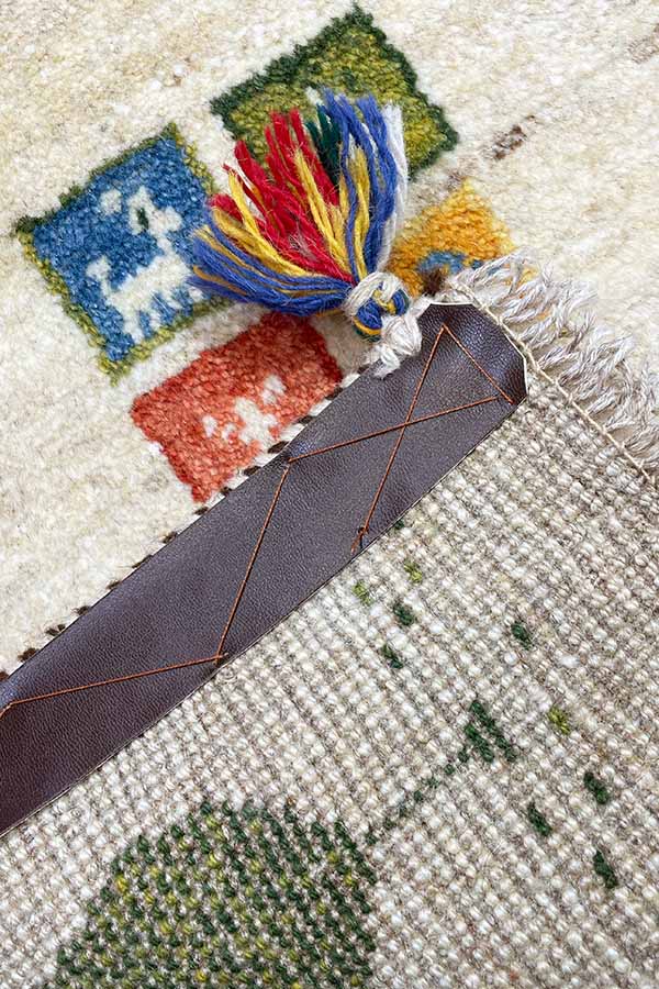 手織りペルシャギャッベ玄関マット。ナチュラルウールのベースカラーで、羊毛本来の色合い。模様にはヤギと生命の樹の意味が込められている。