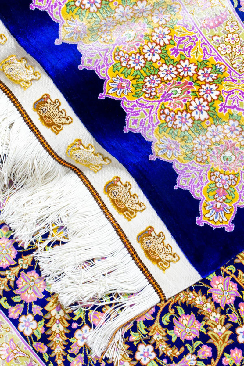 イラン・クム産のシルク手織りペルシャ絨毯、ライオン模様とロイヤルブルーのベースカラー