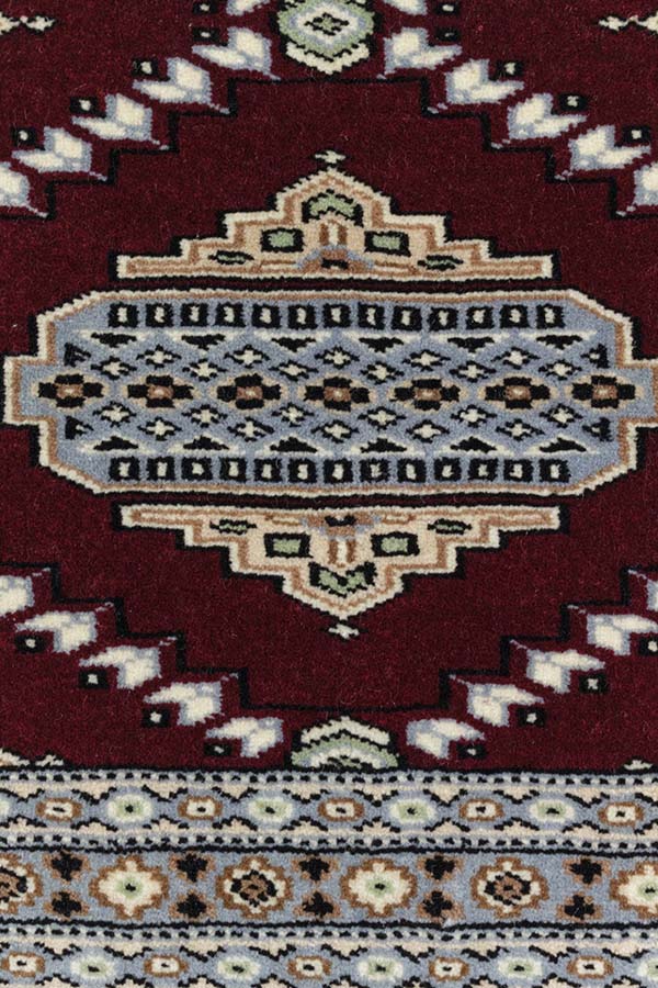 パキスタン絨毯ランク最上位。手触りはみっちりとしており、細やかなデザインがワインレッドの背景に映える。模様の詳細。