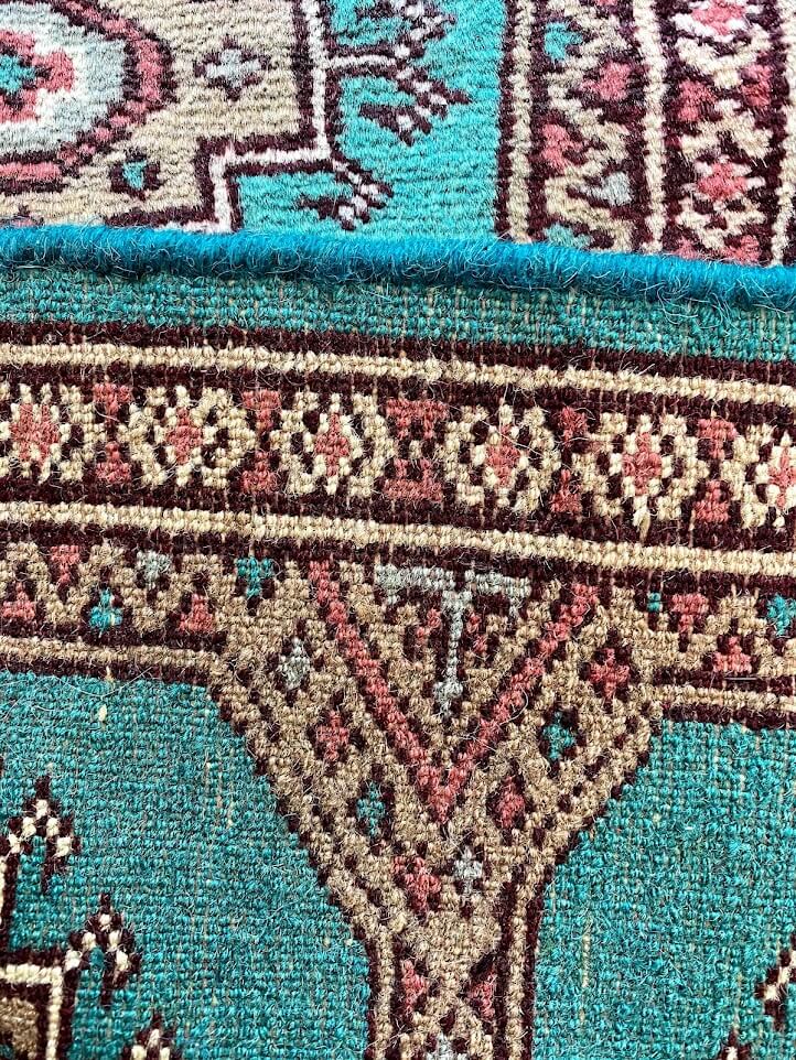 絨毯の裏面や縁取り部分のクローズアップ。織りの詳細や品質を確認できる。