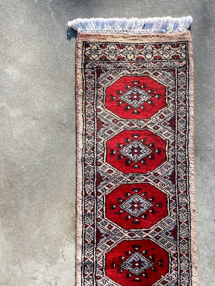 鮮やかな赤色ベースのパキスタン手織り絨毯。ウール素材で、白い部分には光沢のあるシルクが使用。商品番号35309。
