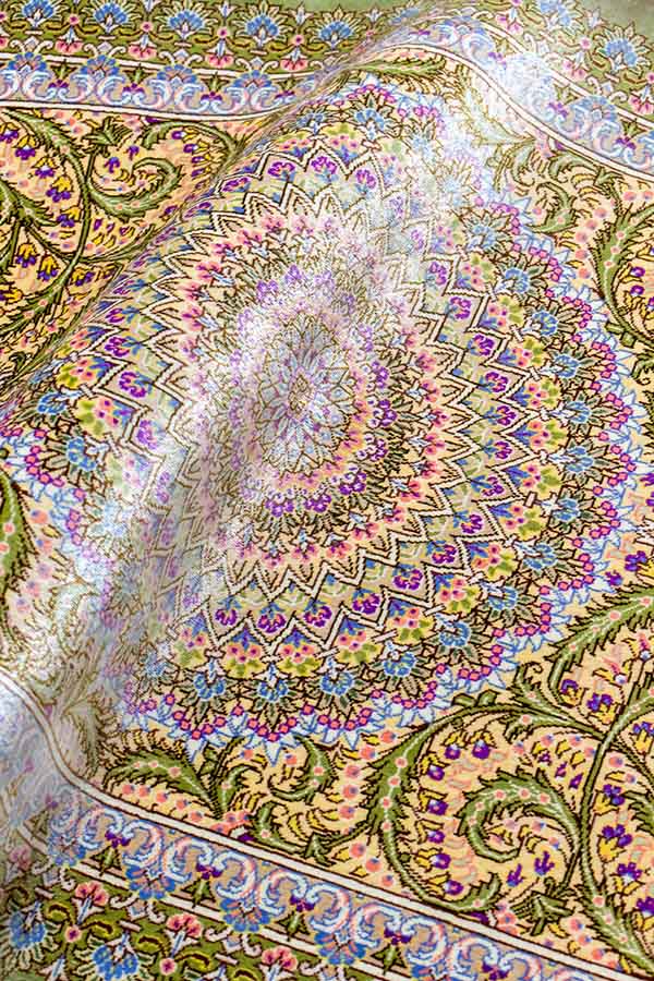 クム産のシルク手織りペルシャ絨毯、クリームグリーンの枠と多彩なメダリオン文様