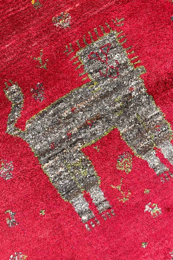 赤色のベースにライオンや鹿が描かれたペルシャギャッベ 