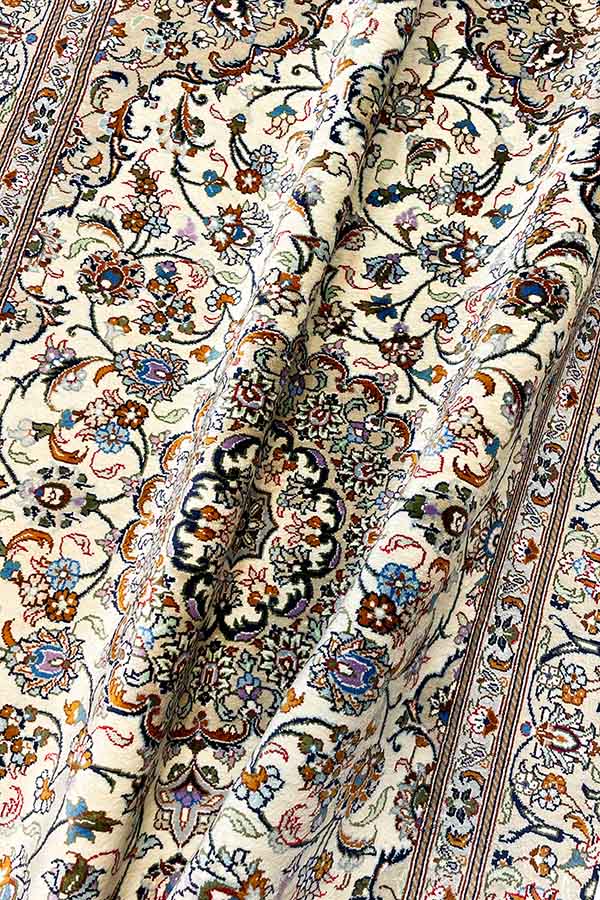 ペルシャ・クム産のシルク製ペルシャ絨毯玄関マット。オフホワイトベースに唐草模様とメダリオンデザイン。