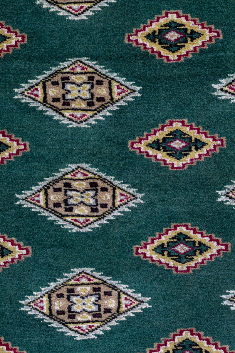グリーンベースの絨毯、細部のデザインにシルクを使用。肌触り滑らか、艶やかな仕上がり。