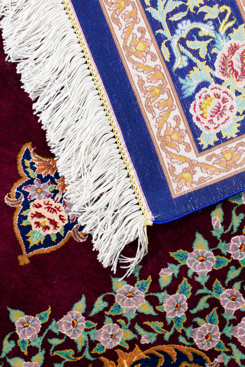 イラン・クム産、ムカダム工房のシルク手織りペルシャ絨毯、ワインレッドフィールドとブルーメインボーダー