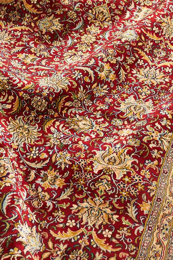 カシミール産の高品質シルク手織り絨毯。全体的に黄色味を帯びた温かく落ち着いたヴィンテージライクなデザイン。シルク特有の美しい光沢となめらかな肌触りが特徴。サイズ約216cm x 309cm（フリンジを含まず）の光沢