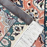 ペルシャ・ナイン製のペルシャ絨毯ウール&シルクの手織り絨毯。サーモンピンクとターコイズグリーンの模様が特徴。